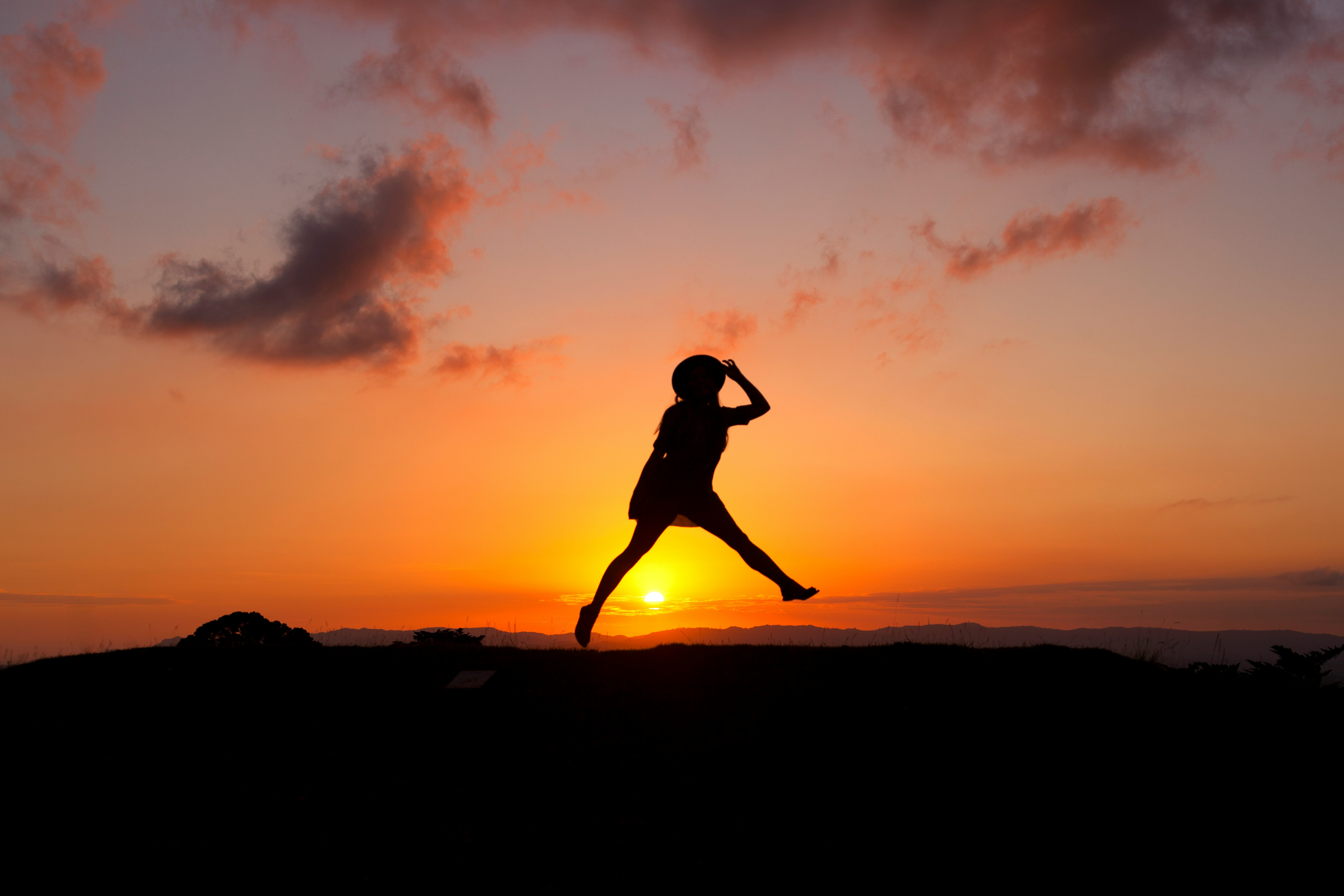 silhouette of human jumping during sunset